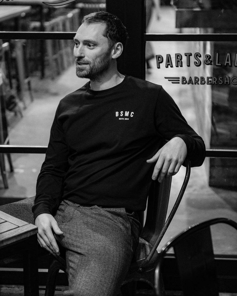 Model wearing Bike Shed Moto Co ESTD Black Longsleeve in the Bike Shed London Restaurant 
