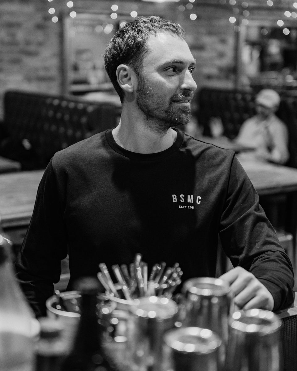 Model wearing Bike Shed Moto Co ESTD Black Longsleeve in the Bike Shed London Restaurant 