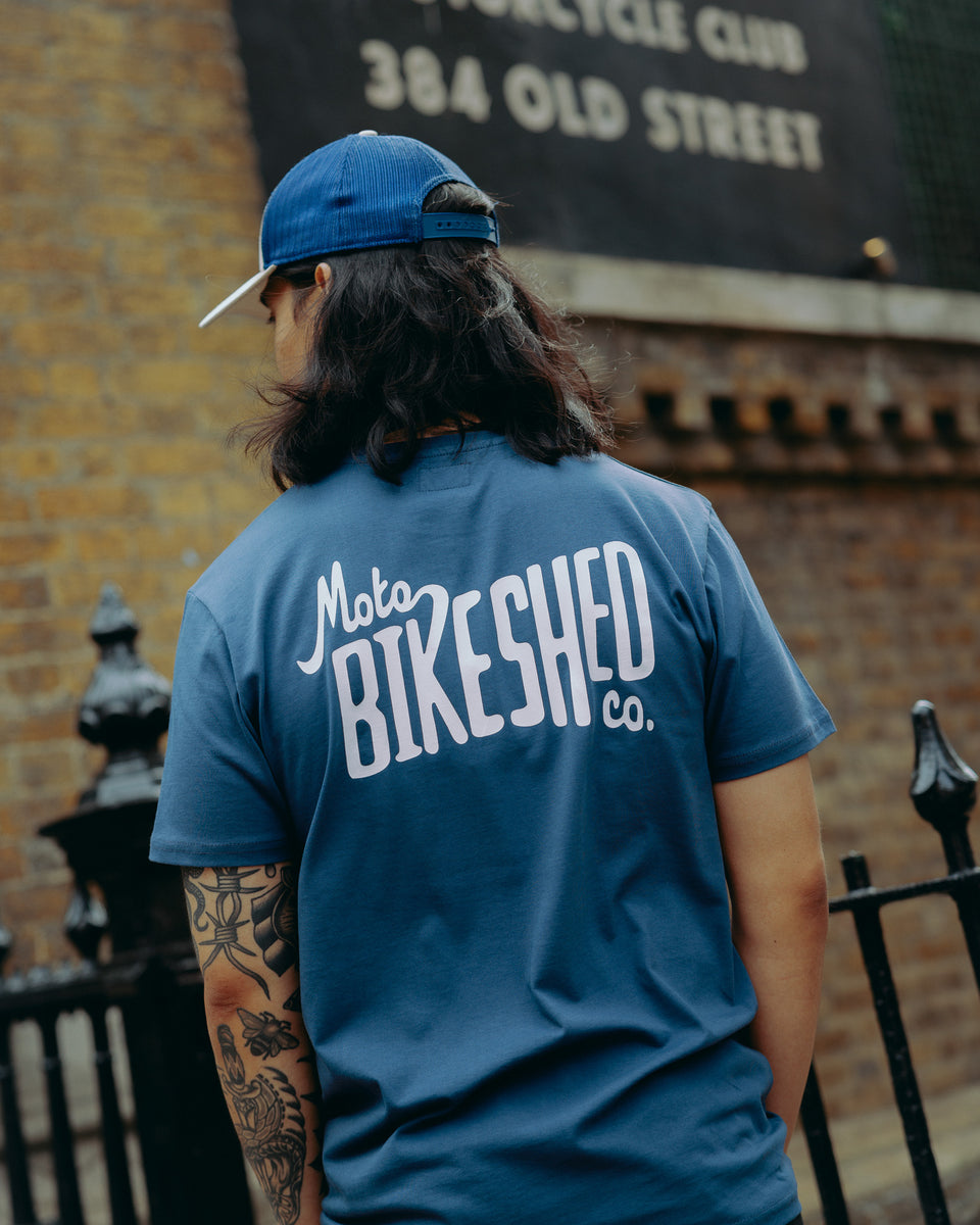 model wearing navy blue t-shirt with 'Moto Bikeshed co'  logo - back