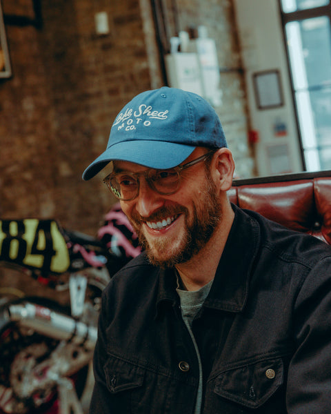 BSMC Desert Race Cap - Blue worn by model with motorcycle in the background